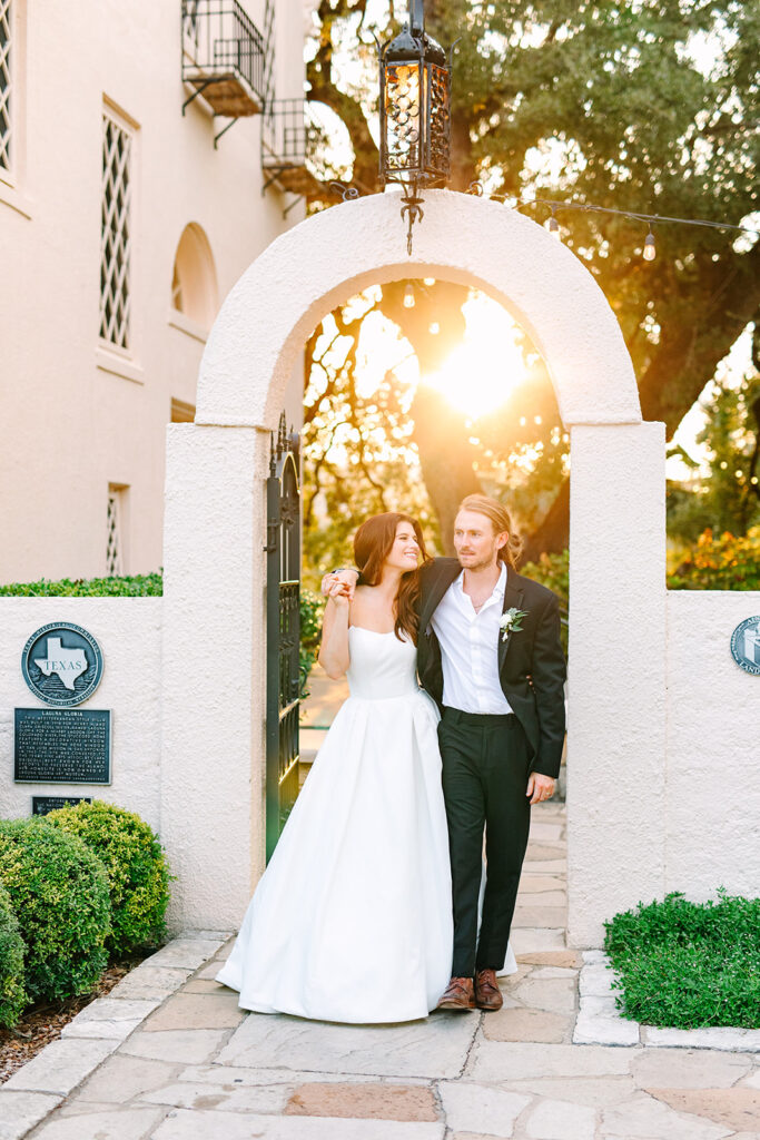 bride and groom walking under arch at Laguna Gloria