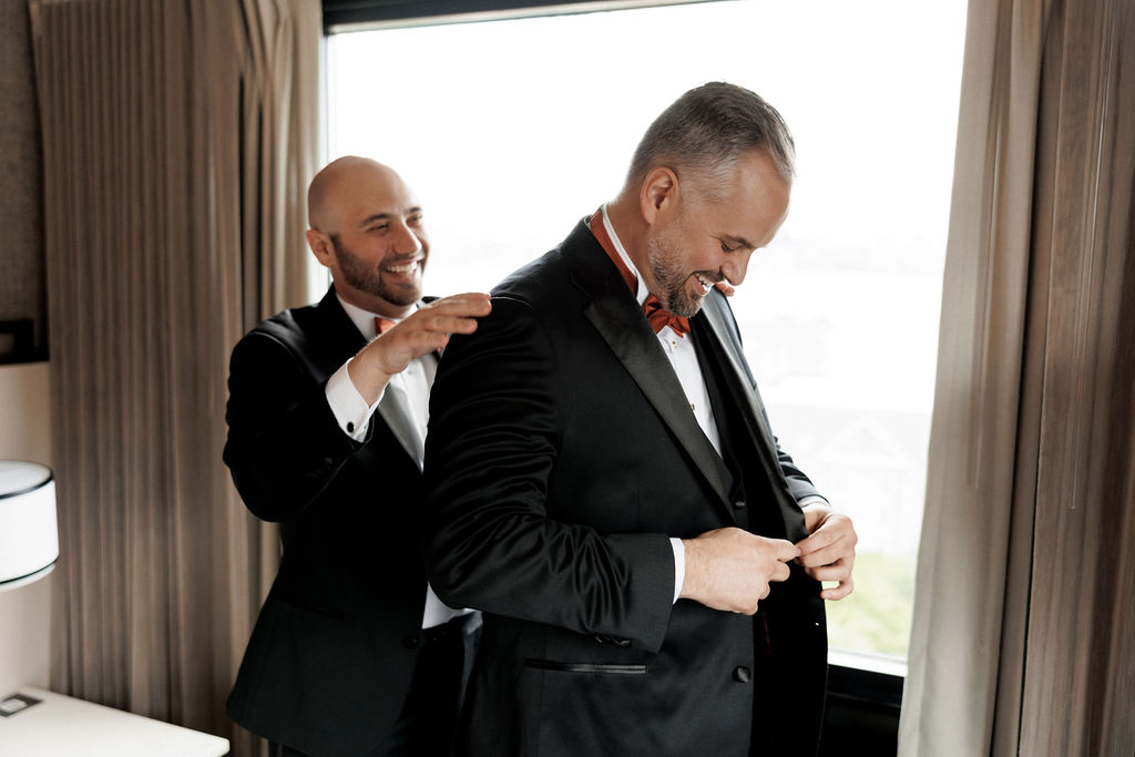 groom putting on jacket